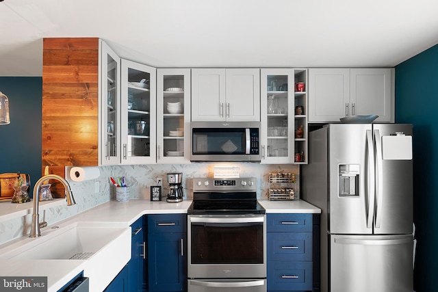 kitchen with white cabinets, blue cabinets, sink, and appliances with stainless steel finishes