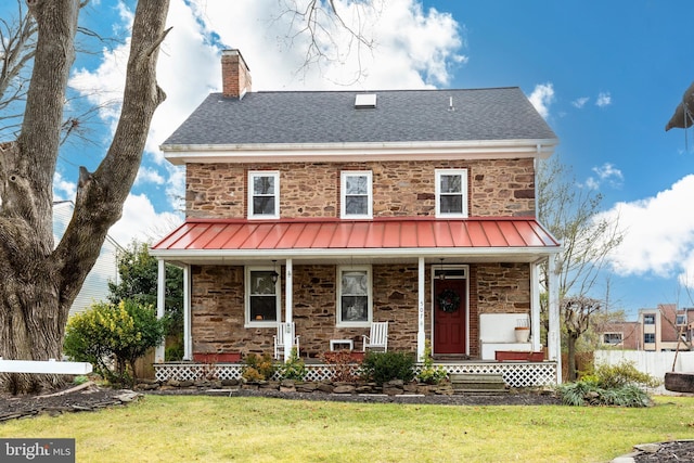 view of front of property with covered porch and a front yard