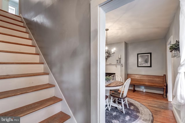 stairs with a chandelier and wood-type flooring