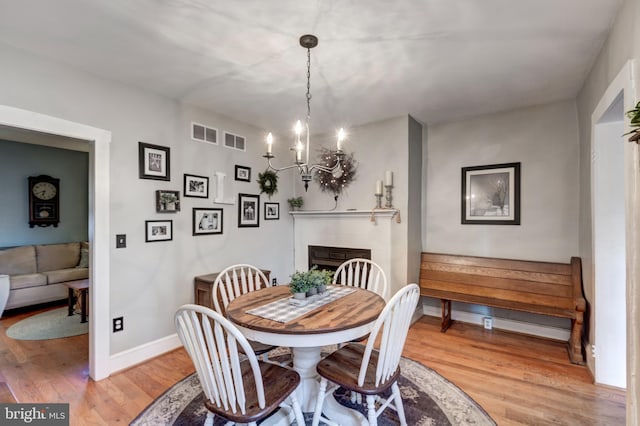 dining space with wood-type flooring and a notable chandelier