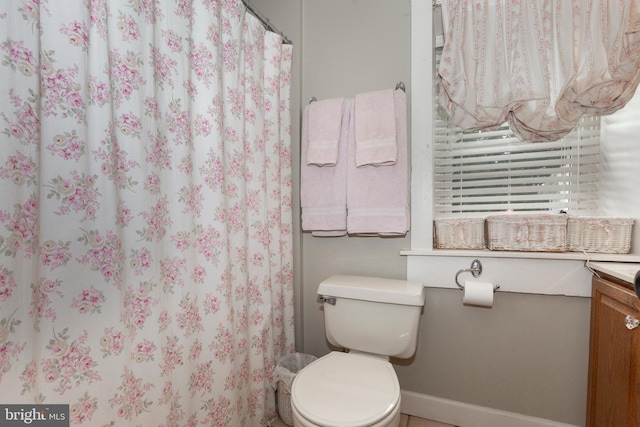 bathroom featuring a shower with curtain, vanity, and toilet