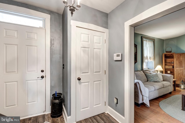 entrance foyer with hardwood / wood-style floors and an inviting chandelier