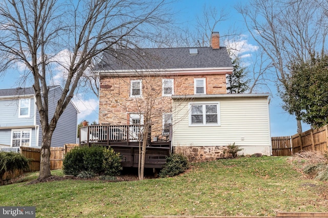 back of house featuring a lawn and a wooden deck