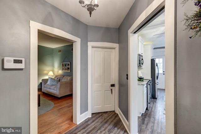 hall with dark hardwood / wood-style flooring and a chandelier