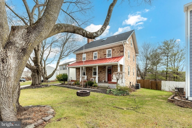 view of front of property featuring central AC unit, covered porch, and a front lawn