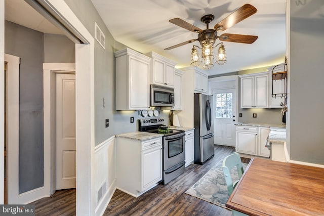 kitchen with white cabinetry, stainless steel appliances, and light stone counters