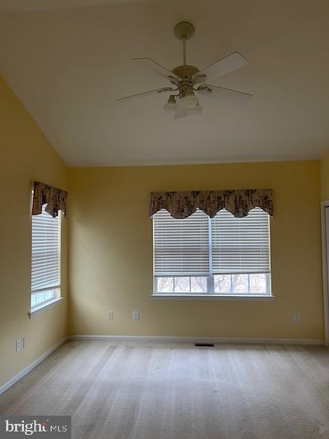 empty room with light carpet, a wealth of natural light, high vaulted ceiling, and ceiling fan