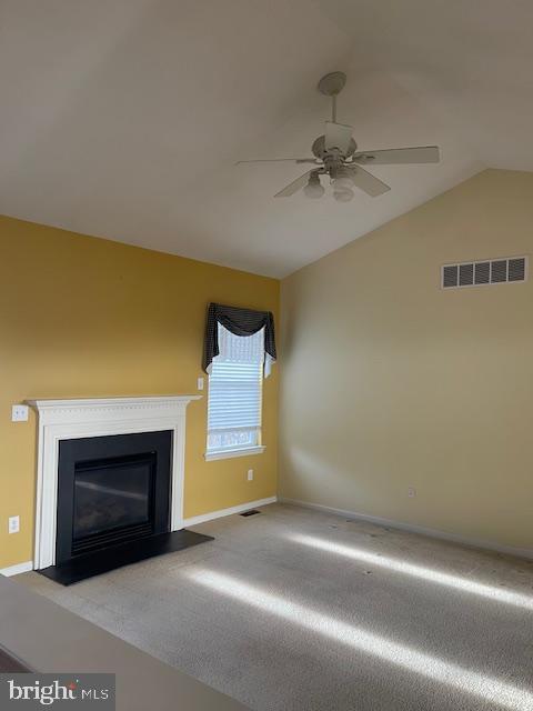 unfurnished living room with lofted ceiling, light carpet, and ceiling fan