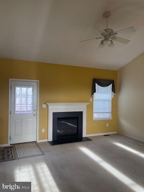 unfurnished living room featuring vaulted ceiling and ceiling fan