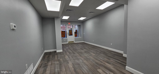 spare room with a paneled ceiling and dark wood-type flooring