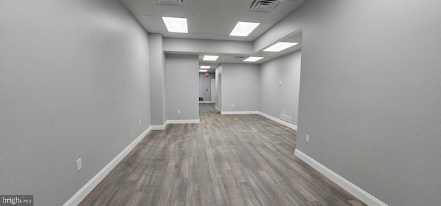 interior space with a paneled ceiling and wood-type flooring