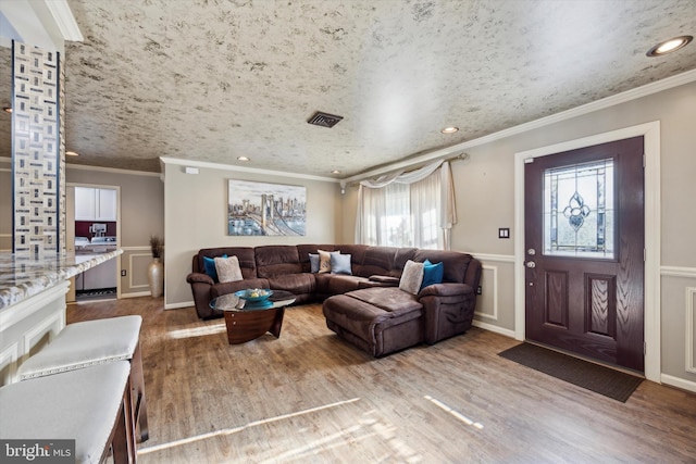 living room featuring hardwood / wood-style floors, crown molding, and a wealth of natural light