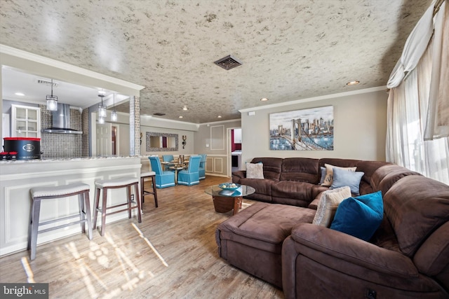 living room with crown molding and light hardwood / wood-style floors