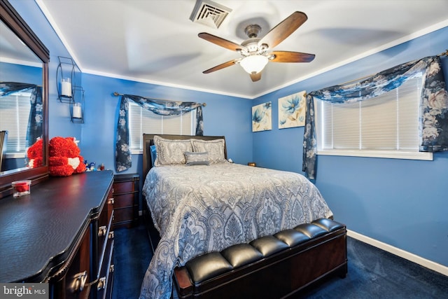 bedroom featuring dark colored carpet, ceiling fan, and ornamental molding