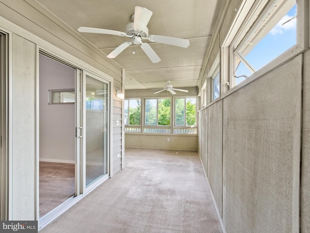 unfurnished sunroom with ceiling fan