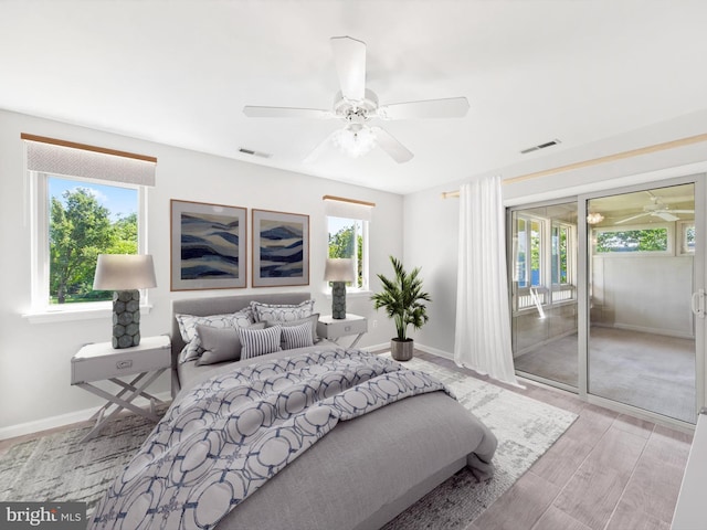 bedroom with ceiling fan, access to outside, and multiple windows