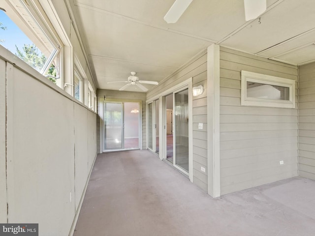 unfurnished sunroom with ceiling fan