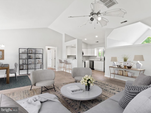 living room with ceiling fan, sink, vaulted ceiling, and hardwood / wood-style flooring