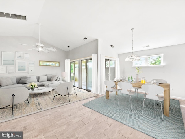 living room featuring ceiling fan with notable chandelier and lofted ceiling