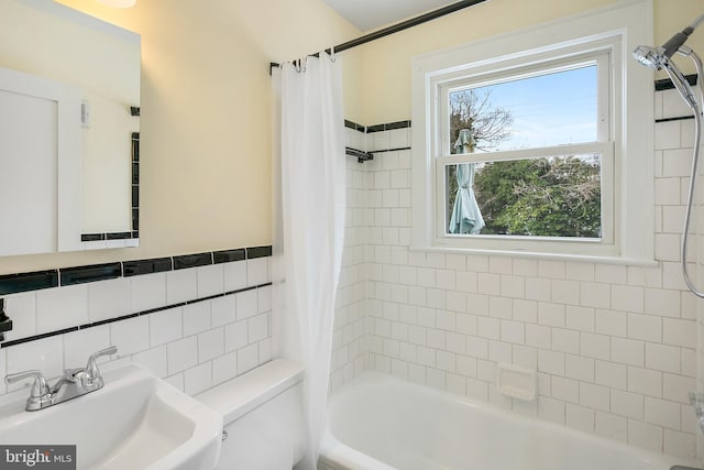 full bathroom featuring shower / tub combo, tile walls, a healthy amount of sunlight, and sink