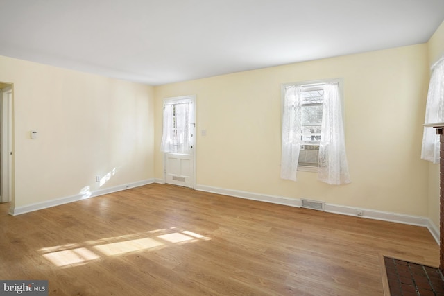 spare room with cooling unit and light hardwood / wood-style floors