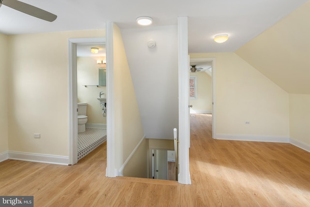 hallway with light hardwood / wood-style floors and lofted ceiling