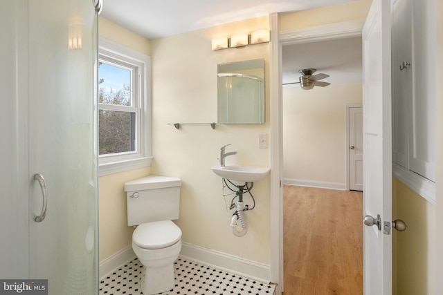 bathroom featuring an enclosed shower, ceiling fan, toilet, and sink