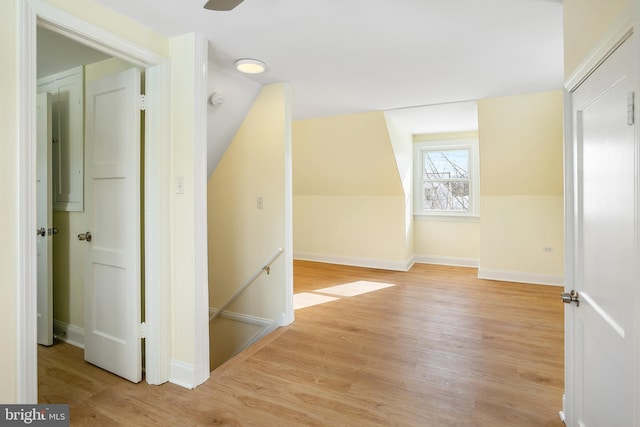 additional living space with light hardwood / wood-style floors and vaulted ceiling