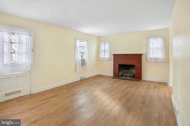 unfurnished living room featuring light wood-type flooring and a fireplace