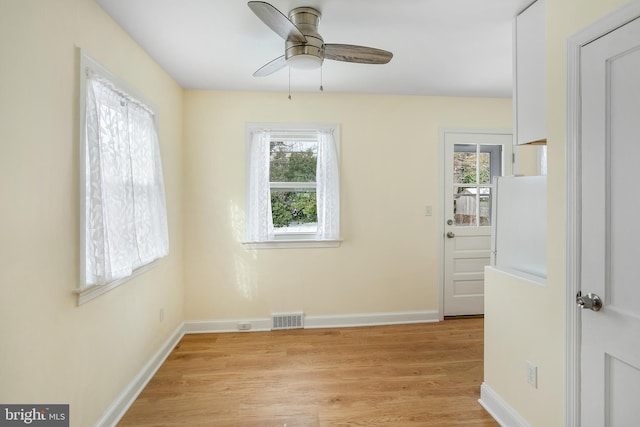 empty room with ceiling fan and light hardwood / wood-style floors