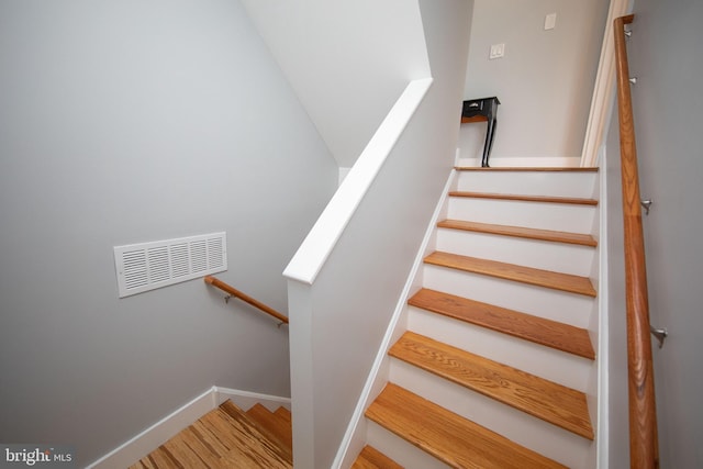 staircase with hardwood / wood-style flooring