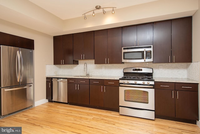 kitchen with appliances with stainless steel finishes, dark brown cabinets, and sink