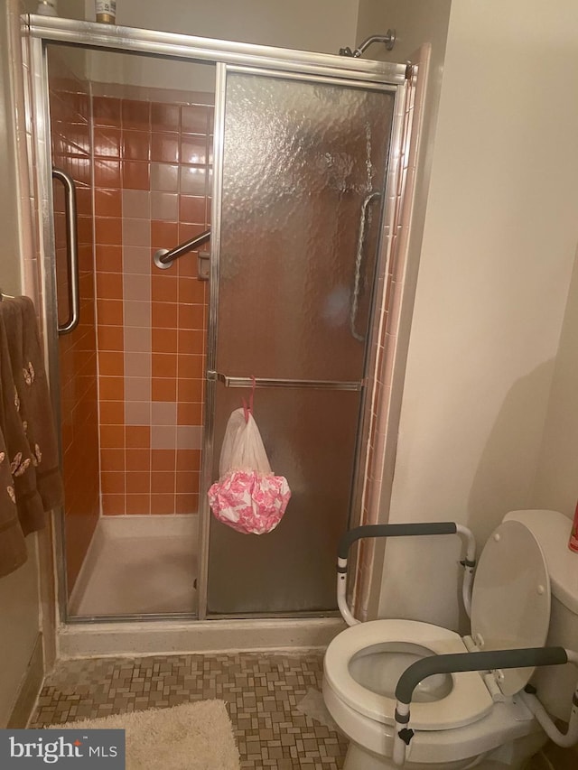 bathroom featuring tile patterned flooring, toilet, and walk in shower