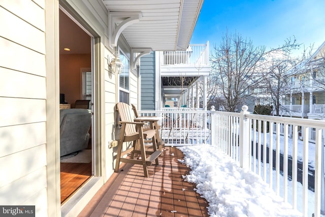 view of snow covered back of property