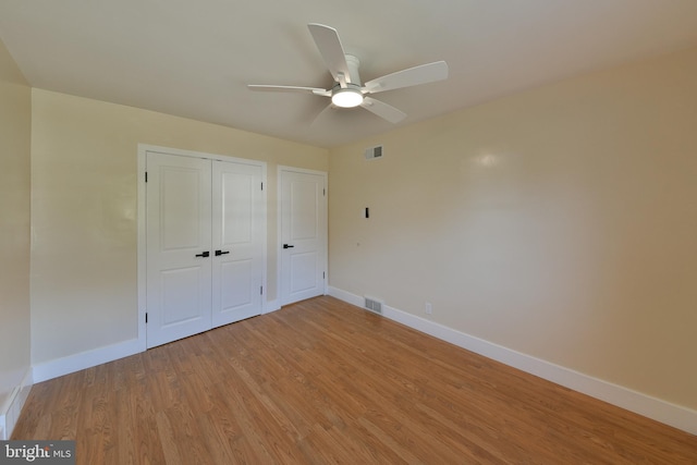 unfurnished bedroom with ceiling fan and light wood-type flooring