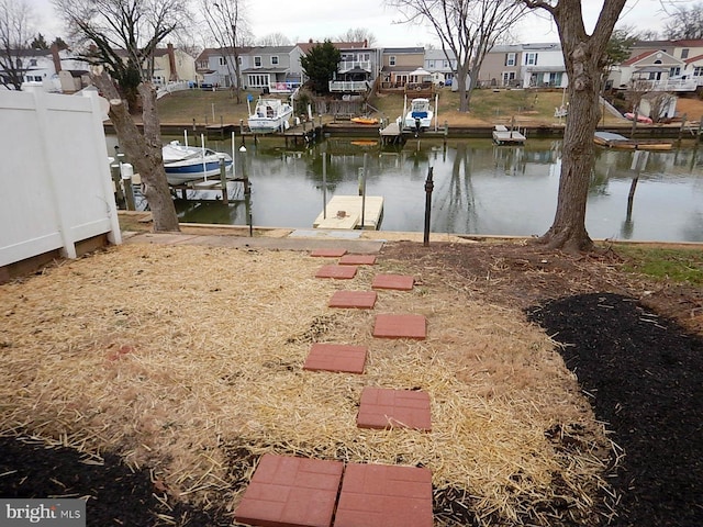 view of yard featuring a dock and a water view