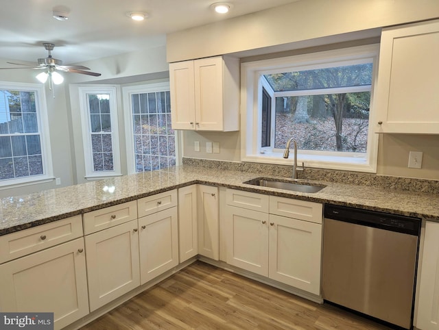 kitchen with dishwasher, sink, light hardwood / wood-style flooring, light stone counters, and white cabinetry