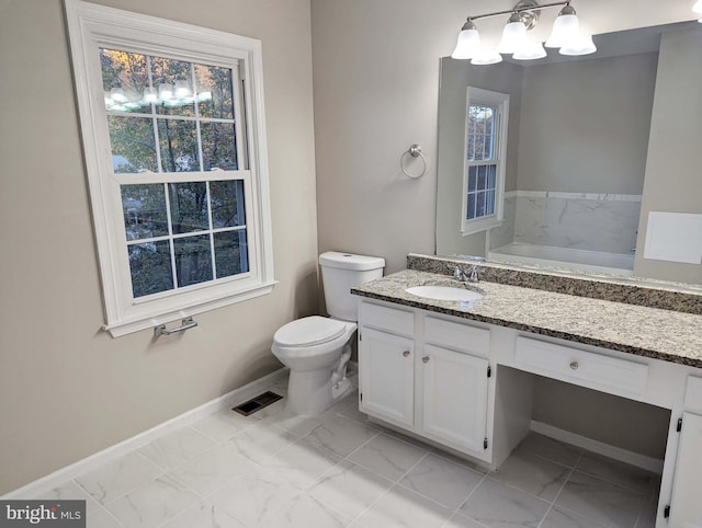 bathroom featuring a tub to relax in, vanity, and toilet