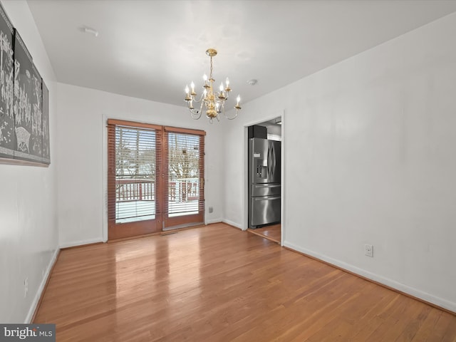 unfurnished dining area featuring hardwood / wood-style floors and a notable chandelier