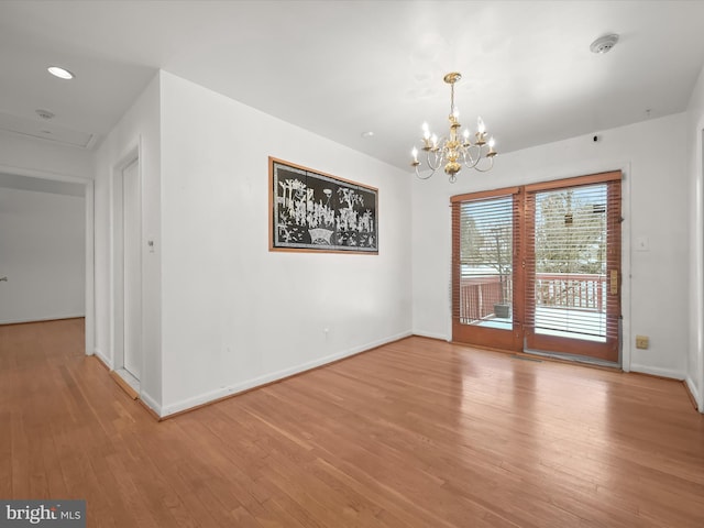 unfurnished dining area featuring light hardwood / wood-style floors and a chandelier