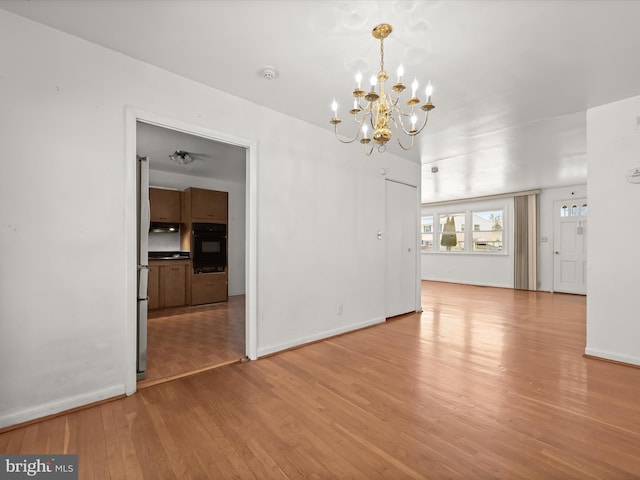 interior space with light hardwood / wood-style floors and a notable chandelier