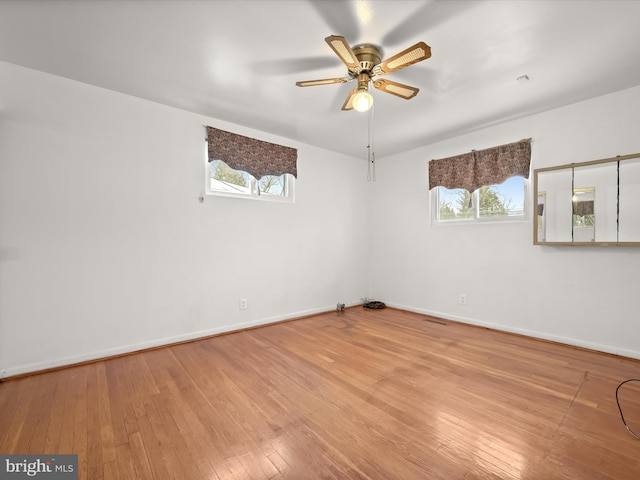 unfurnished room with light wood-type flooring, ceiling fan, and a healthy amount of sunlight