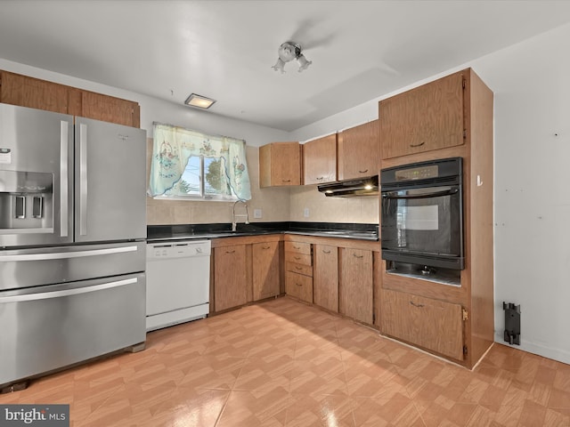 kitchen with stainless steel refrigerator with ice dispenser, dishwasher, sink, backsplash, and oven