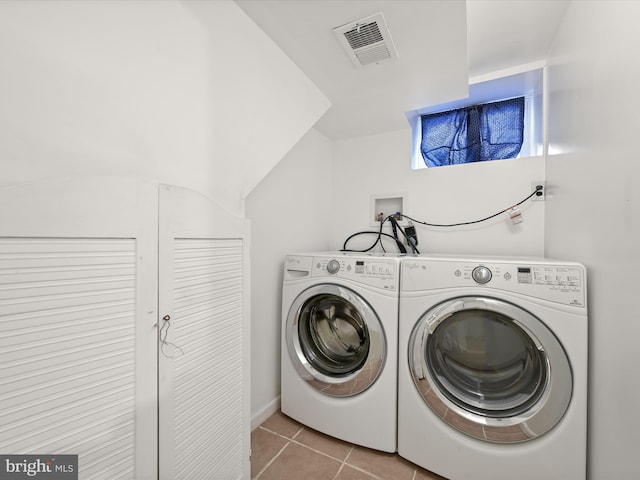 laundry room with light tile patterned flooring and washer and clothes dryer