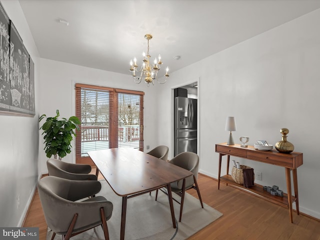 dining area with wood-type flooring and a chandelier