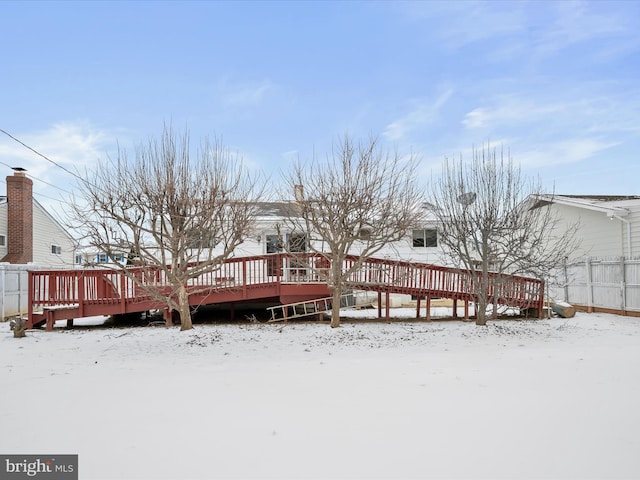 snow covered back of property featuring a wooden deck