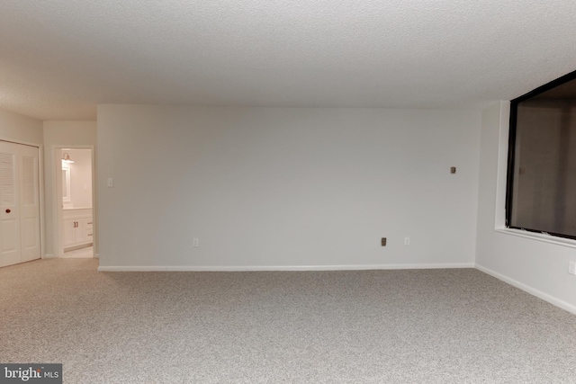 carpeted spare room featuring a textured ceiling