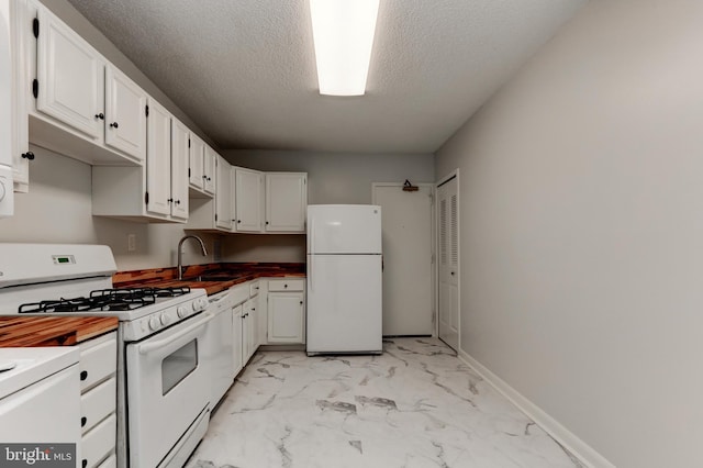 kitchen featuring wooden counters, a textured ceiling, white appliances, sink, and white cabinetry