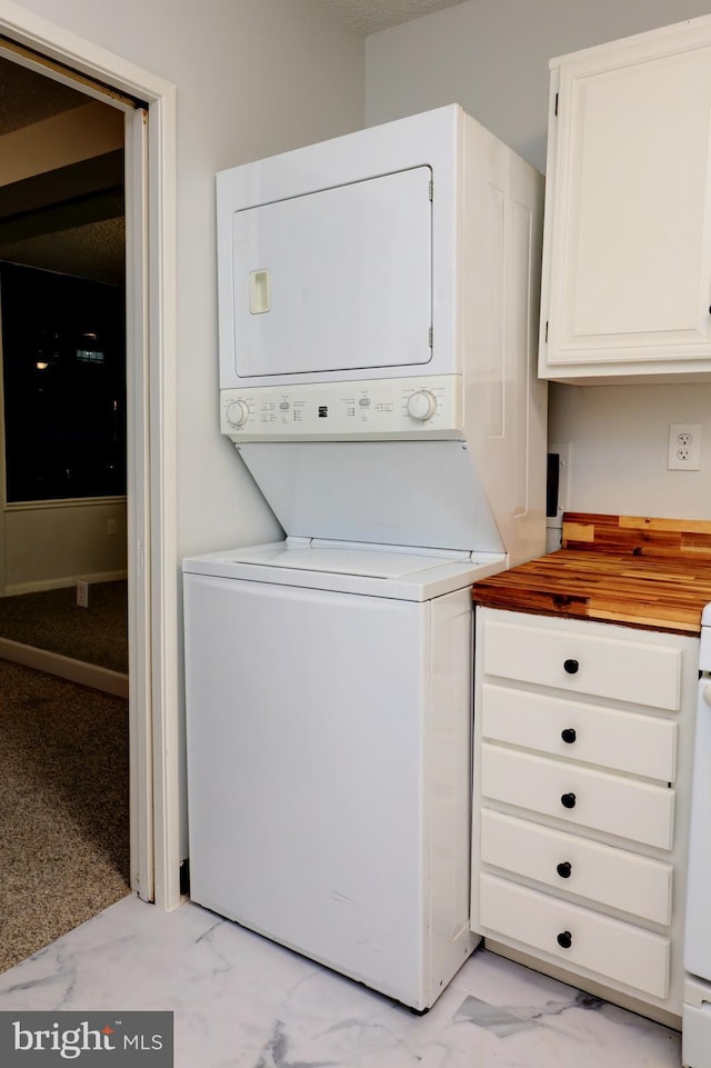 clothes washing area featuring stacked washer / dryer