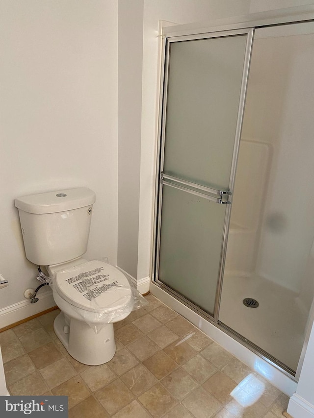 bathroom with walk in shower and toilet